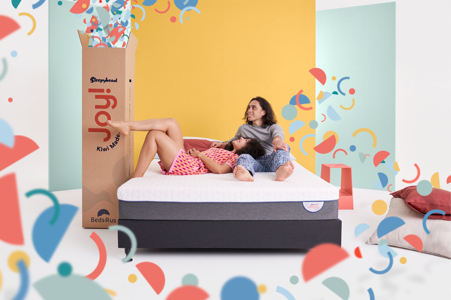 Happy couple lying on the Joy Mattress - Enjoying comfort and support together