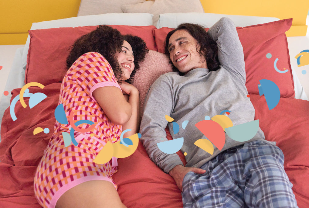 Happy couple lying on the Joy Mattress - Experiencing comfort and support
