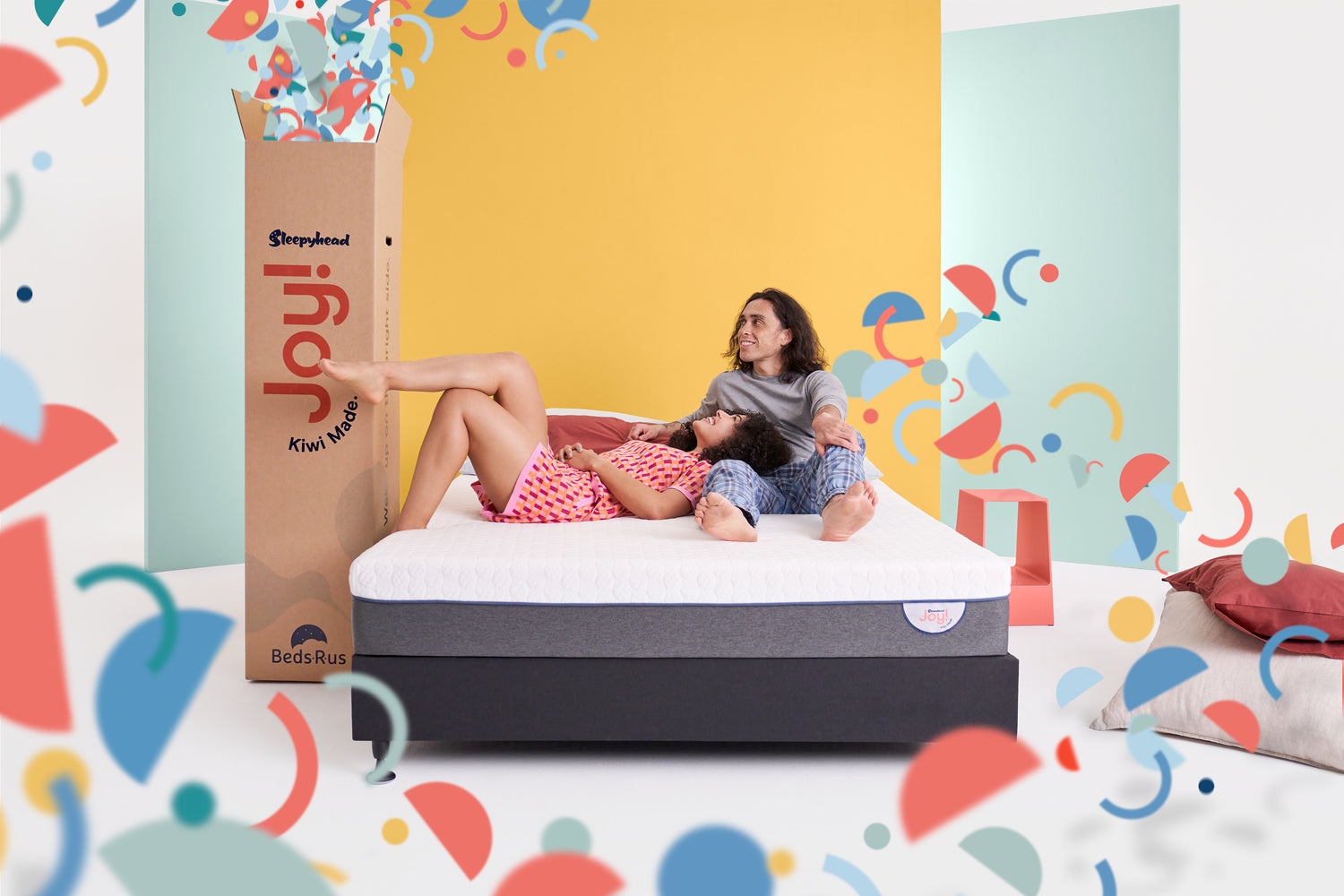 Couple happily lying on the Joy Mattress - Experiencing Comfort