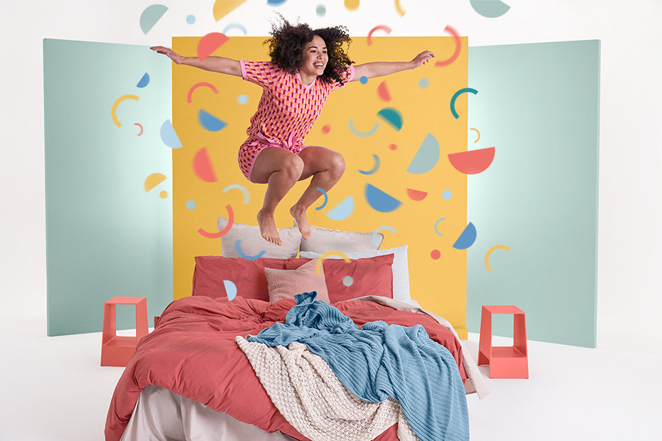 Happy woman jumping on the Joy Mattress