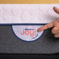 Woman pointing to the Joy logo on the Joy Mattress- Proudly made in New Zealand